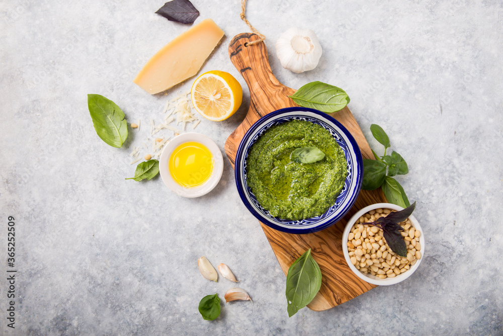 fresh Green basil pesto with italian recipe ingredients over light table copy space for text overhead fresh Green basil pesto with italian recipe ingredients over light table copy space for text overhead