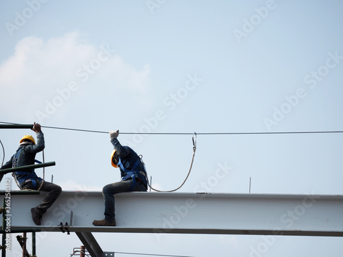Man Working on the Working at height on construction site with blue sky photo