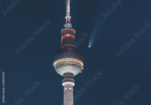 Neowise Comet visible in city of Berlin over TV tower with illuminated night sky. Astro photo during night time with stars. Capital of Germany.