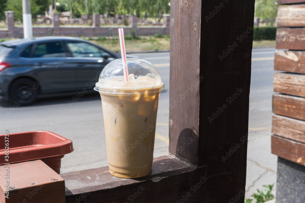 ice coffee takeaway cup on the background of a city street. ice coffee takeaway cup on the background of a city street.
