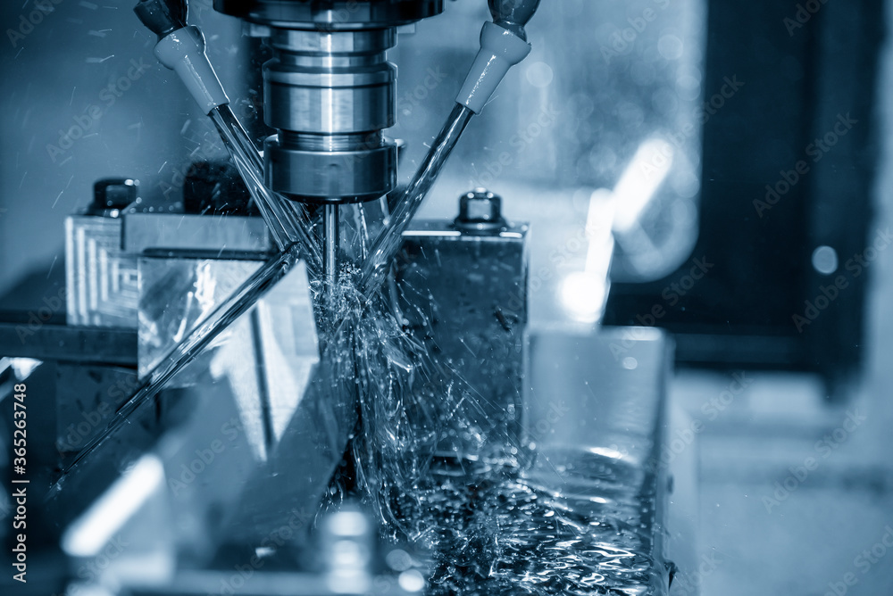 The CNC milling machine cutting the tire mold parts with liquid oil coolant method in vertical