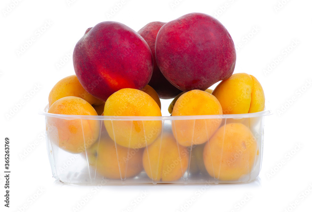 apricot and peach in plastic container on white background isolation apricot and peach in plastic container on white background isolation