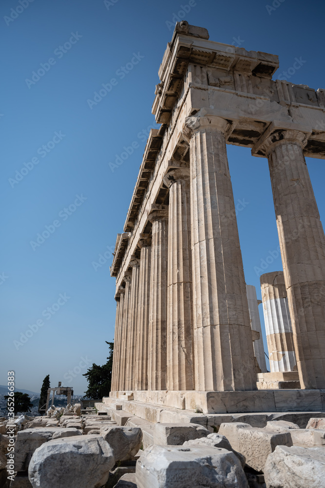 The columns of the Parthenon of the Acropolis in Athens against a blue sky.