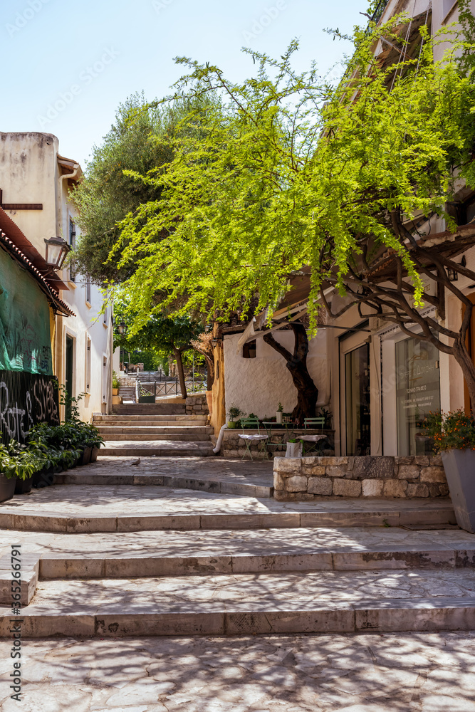 Picturesque quiet alley in the Plaka old town of Athens with steps, trees and flowers.