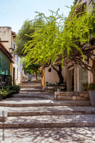 Fototapeta Naklejka Na Ścianę i Meble -  Picturesque quiet alley in the Plaka old town of Athens with steps, trees and flowers.