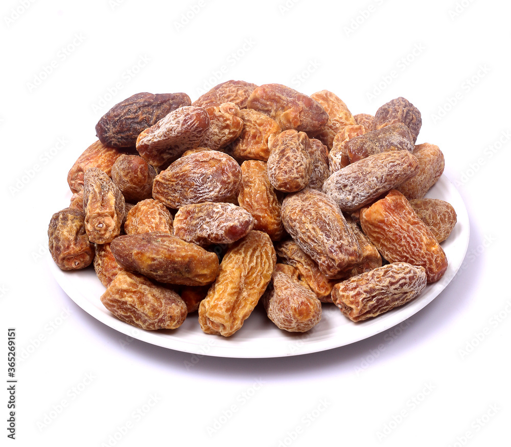 Dry dates or kharek on a plate with white background Dry dates or kharek on a plate with white background