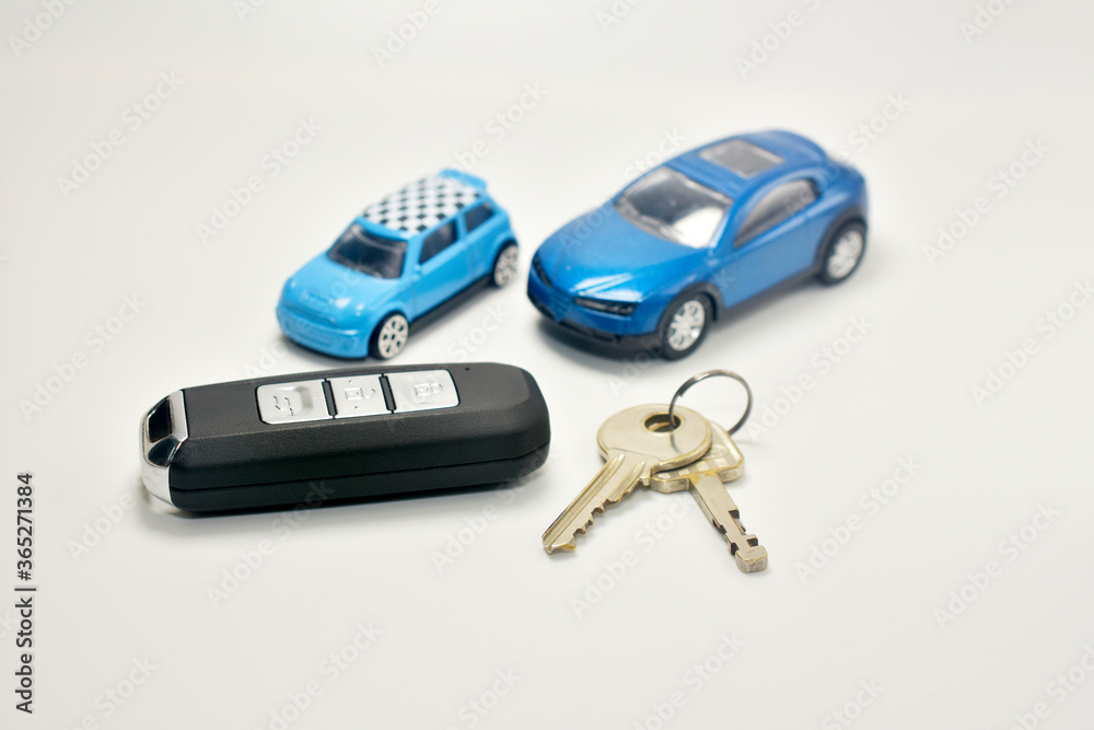 Key car and house on white table and car model background Key car and house on white table and car model background