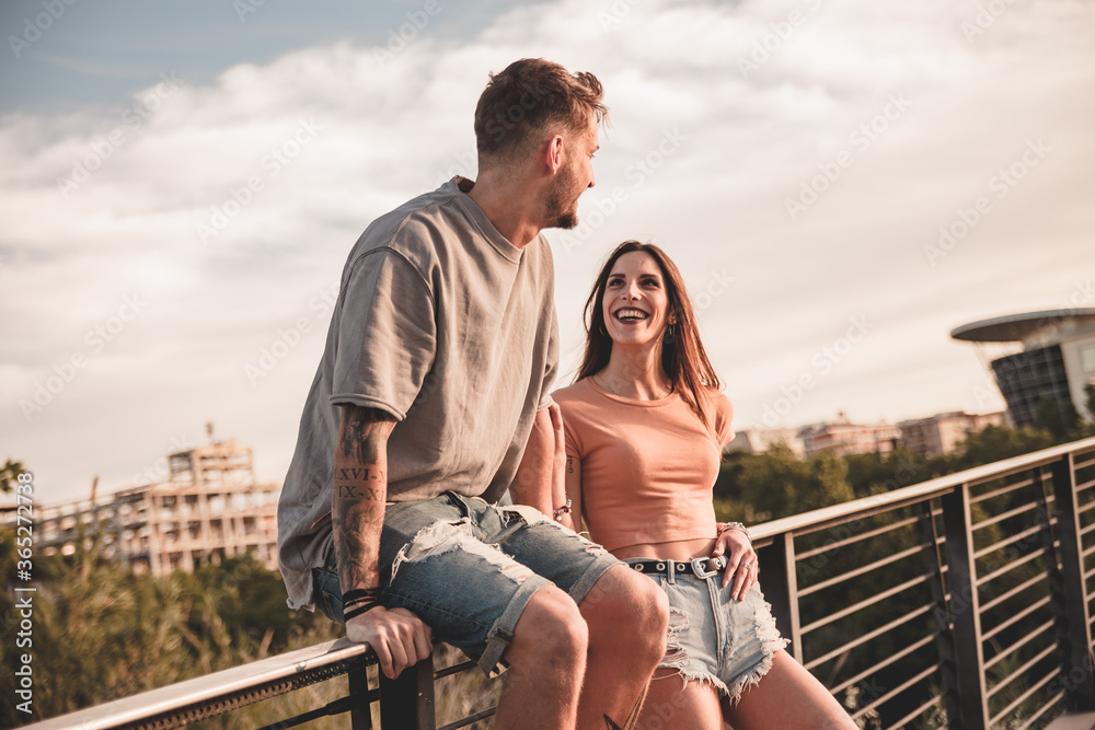 Φωτογραφία Giovane ragazza guarda con felicità il suo fidanzato seduto sul bordo di una rin