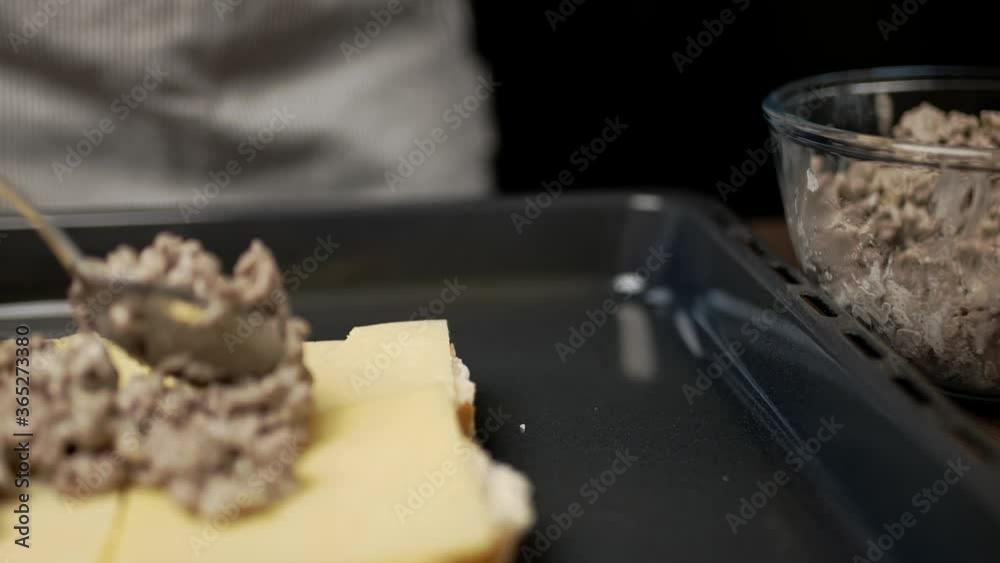 Adding fried ground beef on bread rolls in slow motion. Concept of