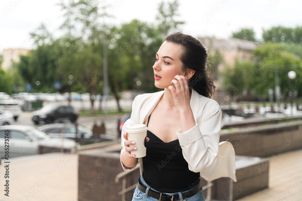 Beautiful cute girl with a cup of coffee outdoors