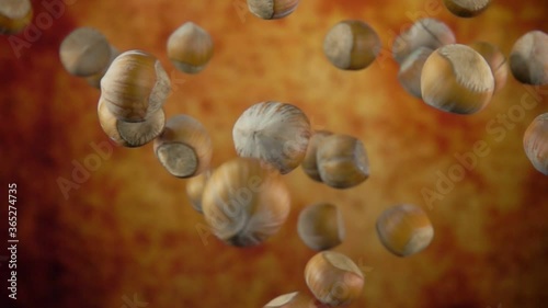 Unpeeled hazelnuts are bouncing on a yellow ochre background in slow motion photo