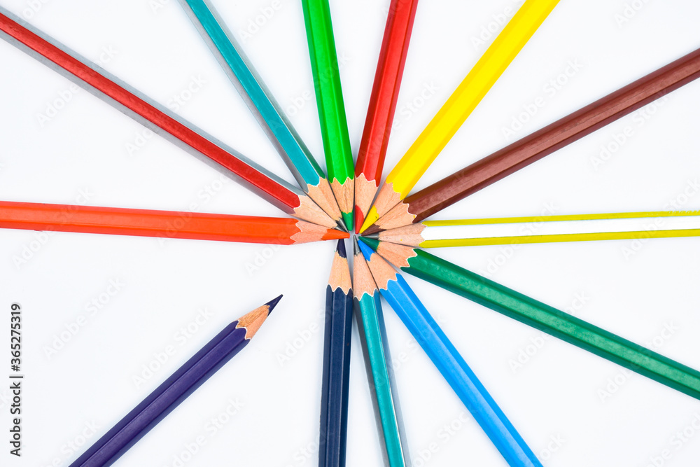 Different colored wood pencil crayons placed on a white paper in a circle