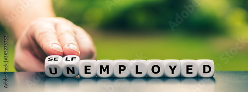 Obraz na płótnie Hand turns dice and changes the expression unemployed to self employed