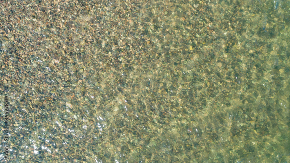 View of multicolored pebble of sea beach under clear water. Pattern of sea stone texture under water. Sea bottom with pebbles through clear water. Natural background. View of multicolored pebble of sea beach under clear water. Pattern of sea stone texture under water. Sea bottom with pebbles through clear water. Natural background.