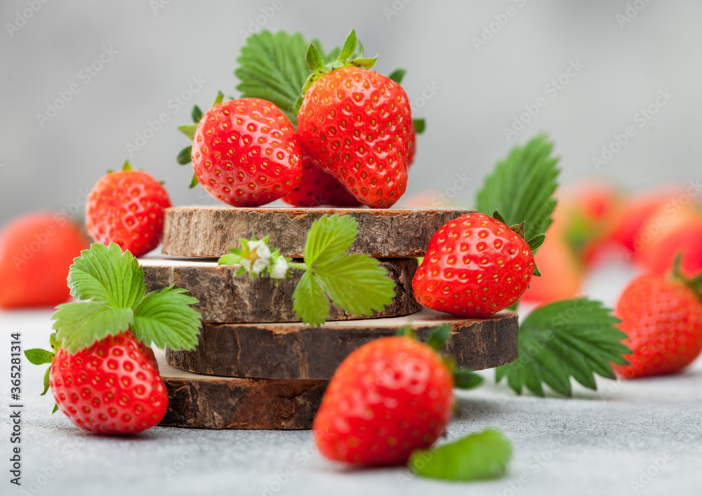 Fresh raw organic summer strawberries with a lot of vitamins and leaf on round timber boards on light background. Fresh raw organic summer strawberries with a lot of vitamins and leaf on round timber boards on light background.
