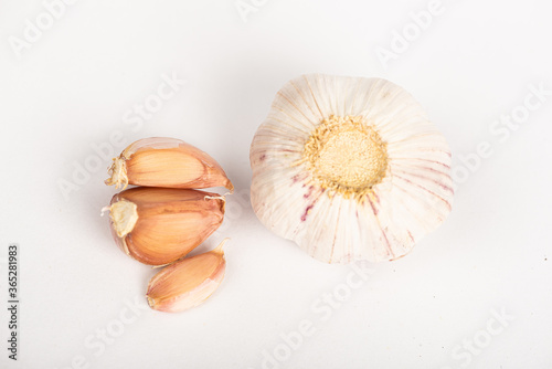 Garlic clove with shell and whole garlic on white background