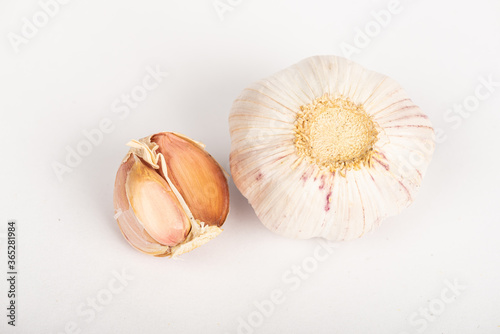 Garlic clove with shell and whole garlic on white background