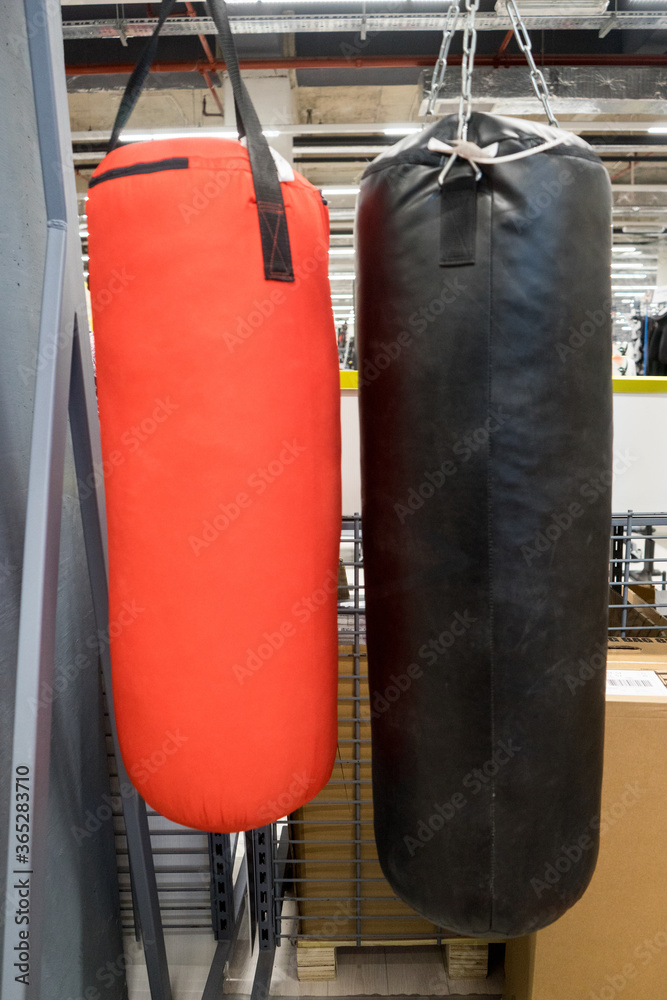 Red and black punching bag for boxer in sports store