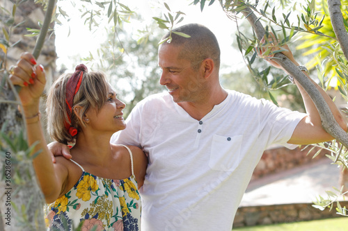 un ragazzo bianco e chiaro scambia effusioni d'amore con sua moglie di origine sudamericana in un parco naturale photo