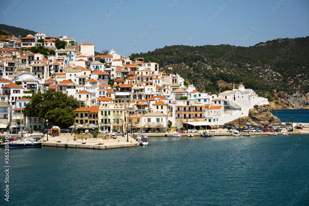 The historical town on Skopelos island seen from the boat when entering the harbour in summer light.