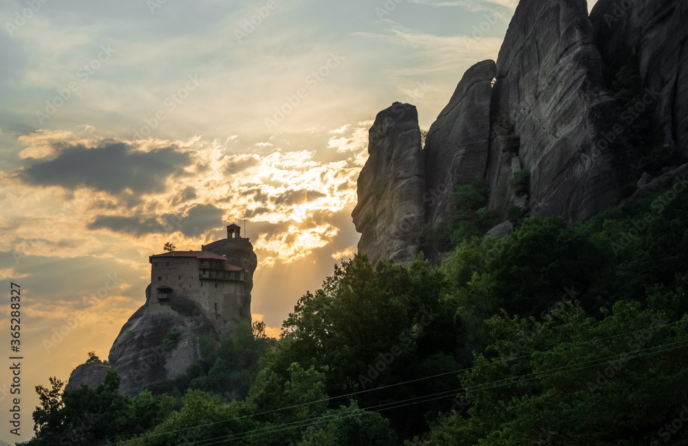 The Meteora monastery Nikolaos Anapafsás with its scenic location on the top of the rocks in Greece with sunset
