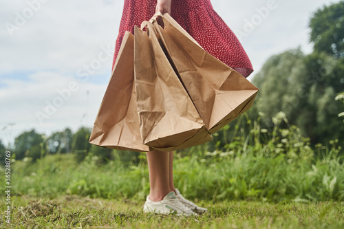 A young girl holds blank paper bags in her hand. Shopping concept. High-quality photo