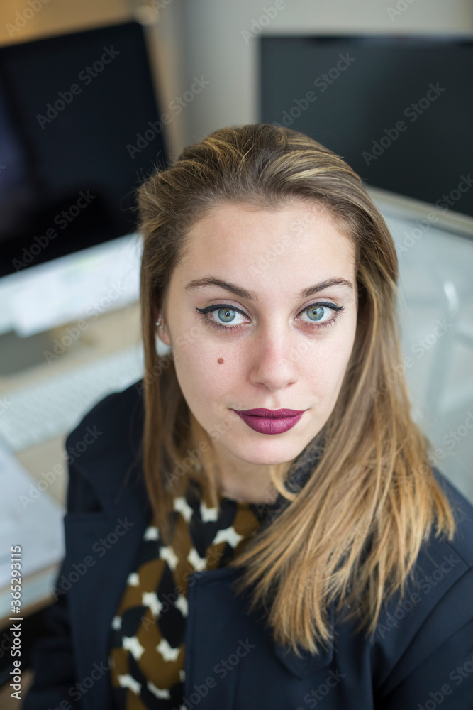 Ritratto di manager bionda con gli occhi chiari che guarda seduta nella propria postazione Ritratto di manager bionda con gli occhi chiari che guarda seduta nella propria postazione