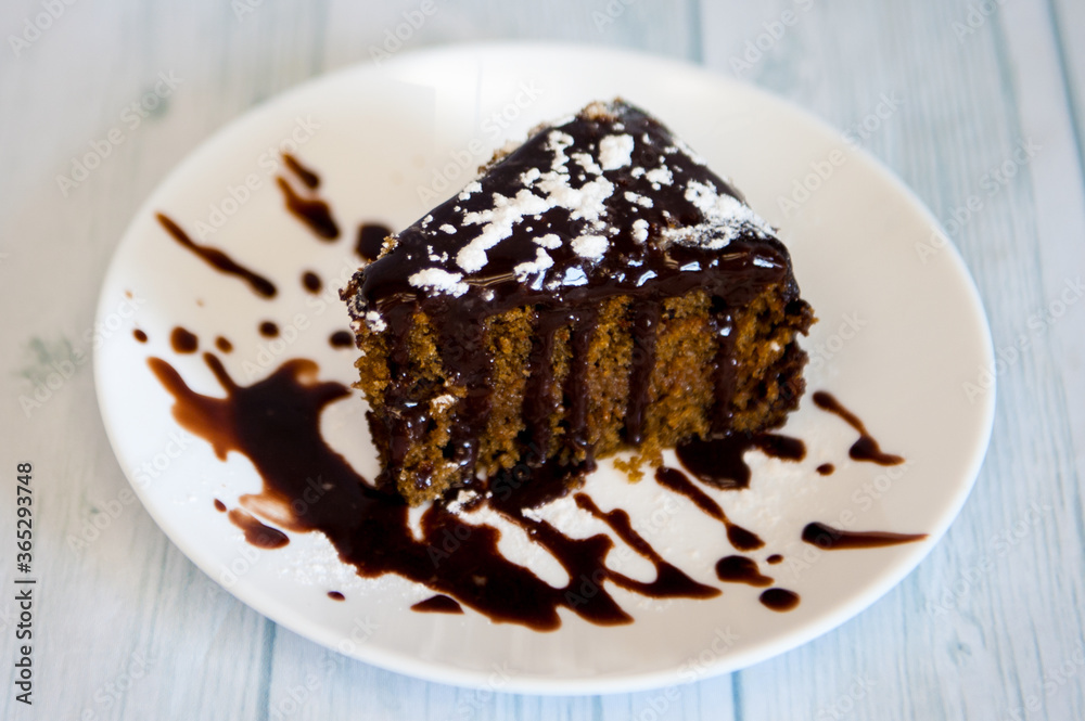 Piece of chocolate cake with dark cream on white plate Piece of chocolate cake with dark cream on white plate