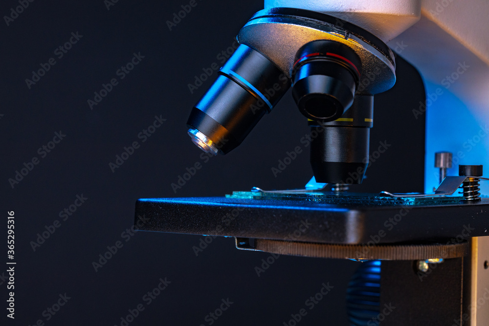 Obraz premium Microscope with lenses close up against dark background