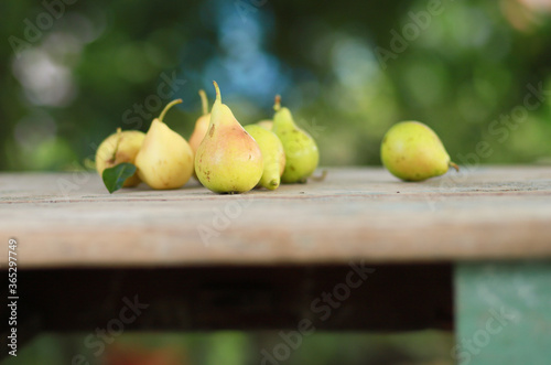 Sweet pear in the summer garden on a wooden table. Summer, juicy, sweet fruits.