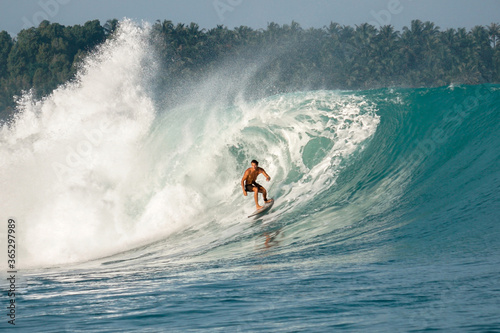 Surfer on perfect blue big tube wave  empty line up  perfect for surfing  clean water  Indian Ocean in Mentawai islands