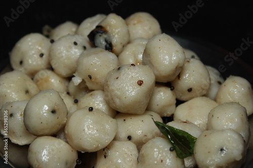 Neer Kozhukkatta / Neer Kozhukattai - Indian Food, Indian home made neer Kozhukattai with steamed rice dumplings and garnished with coconuts curry leaves on top angle view photo