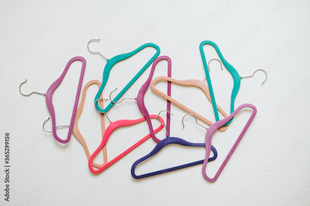 Sustainable responsible consumption concept. Many bright multi-colored velvet pop color hangers on white background. Store, sale, design, empty hanger Sustainable responsible consumption concept. Many bright multi-colored velvet pop color hangers on white background. Store, sale, design, empty hanger