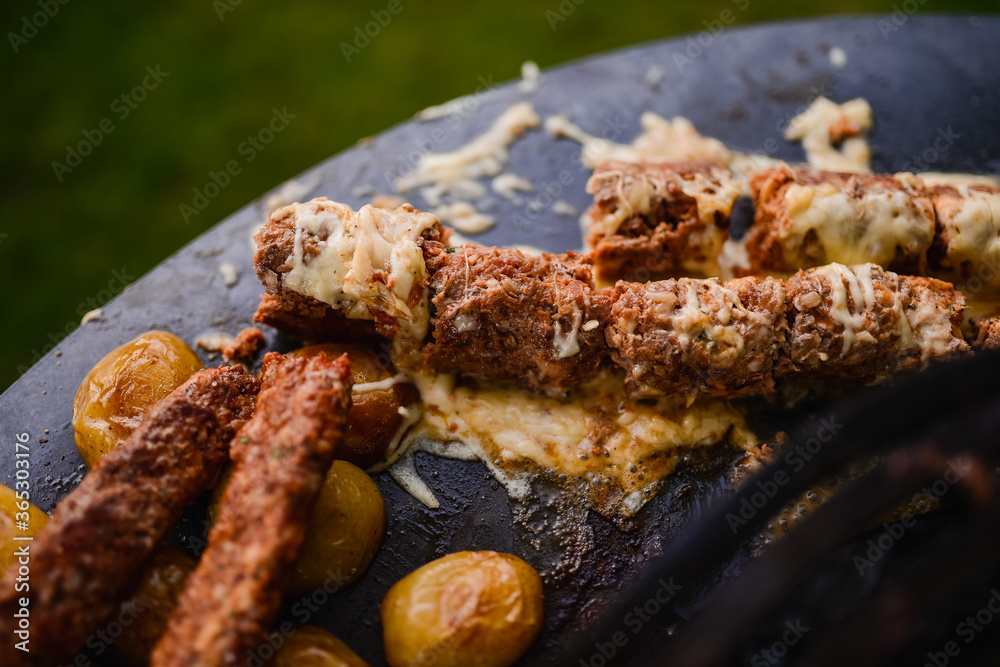 Closeup of minced kebab meat while grilling. Barbecue in the garden