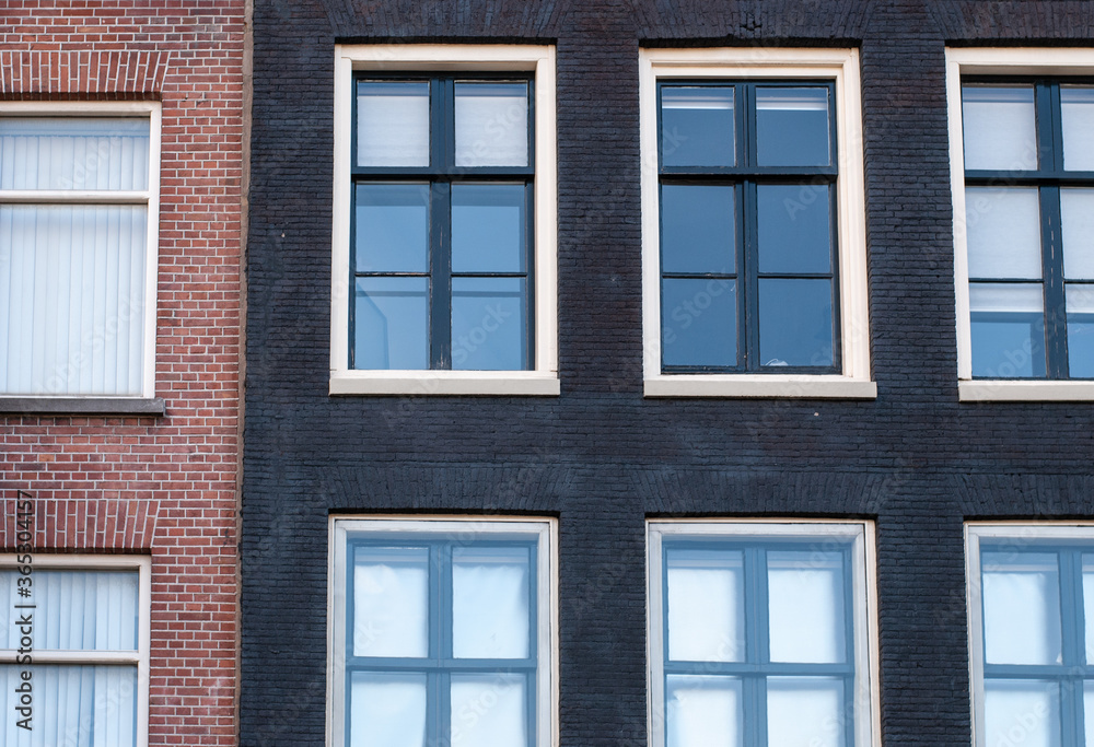 Facade of red and black brick walls with large windows