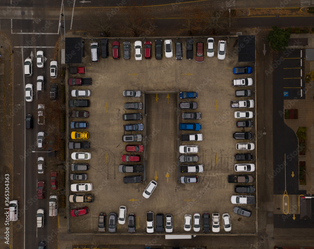 Many cars parked on parking structure in city, drone photo.