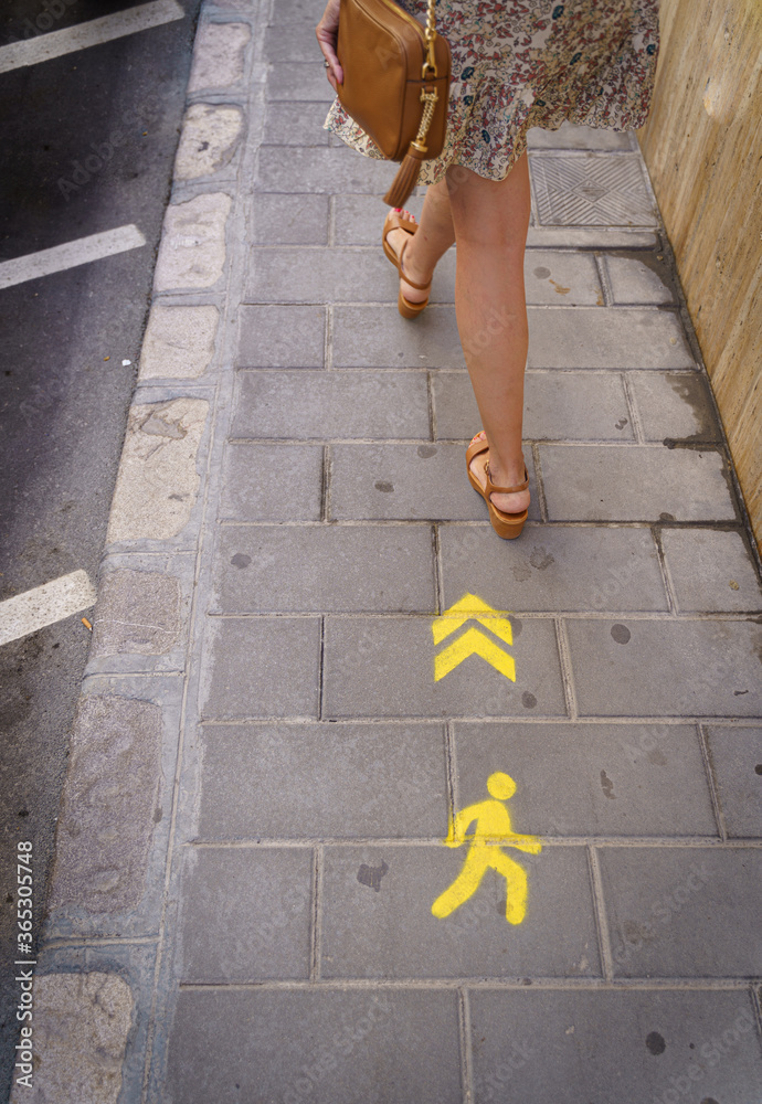 One-way pedestrian sign on the floor to maximize the social distance and preventively prevent contagion by covid-19.