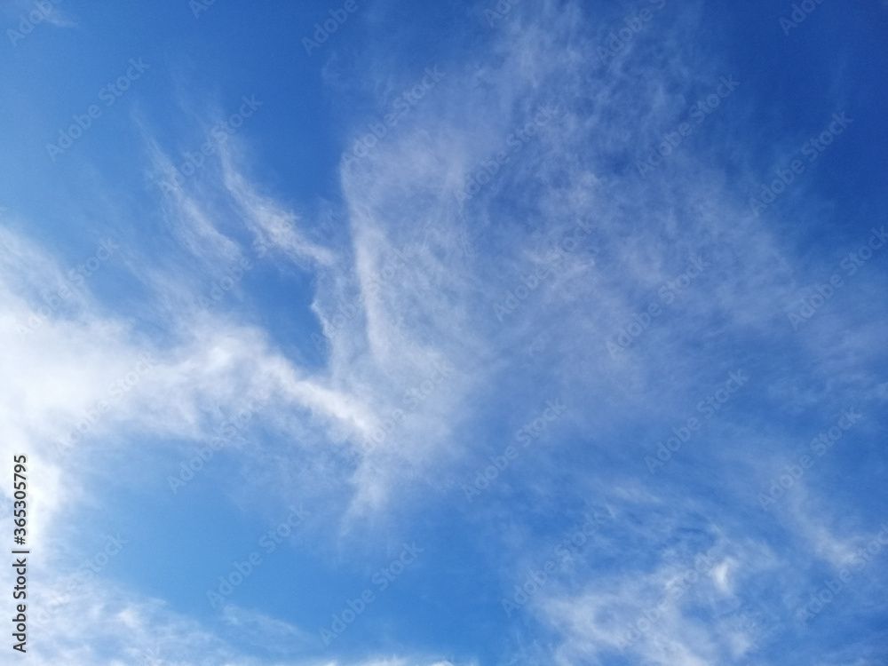 Cirrus clouds on blue sky background.