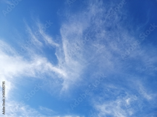 Cirrus clouds on blue sky background.