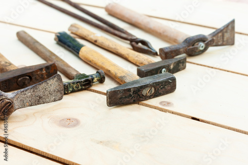 Set of vintage well used hand construction tools for handyman, hammers, on a wooden background .