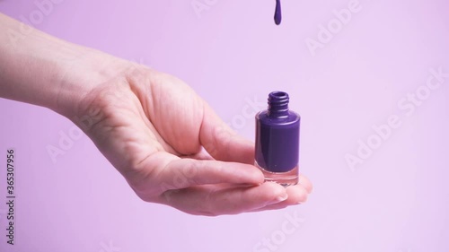 Opening a jar of nail polish. A drop of varnish is dripping.