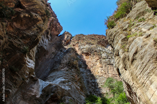 Inside of a natural canyon, huge cliff, sediment layers are visible
