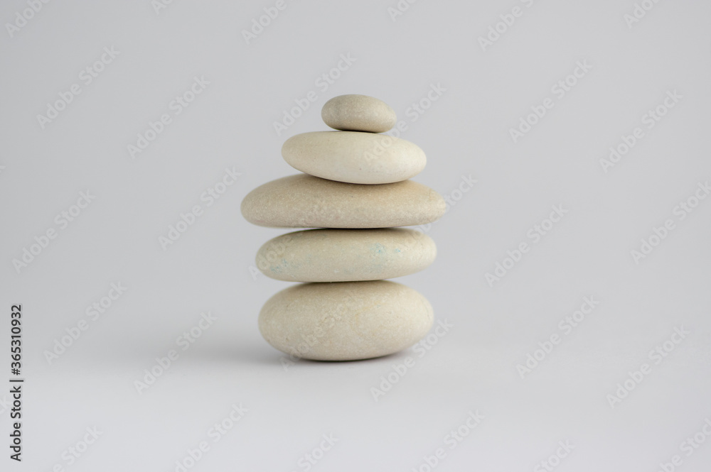 One simplicity stones cairn isolated on white background, group of five white pebbles in tower One simplicity stones cairn isolated on white background, group of five white pebbles in tower