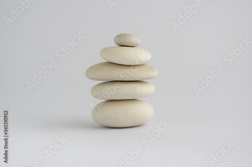 One simplicity stones cairn isolated on white background  group of five white pebbles in tower