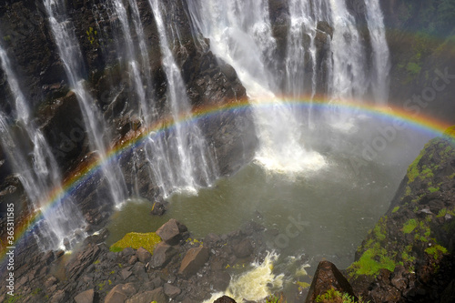 Fototapeta Naklejka Na Ścianę i Meble -  Victoria Falls with rainbow on Zambezi river, falling water from rock, view from Zambia, Africa