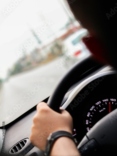 Car driving at 155 km/h, speeding, steering wheel, speedometer and driver's hand are visible photo