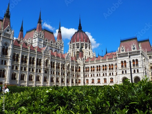 Budapest, Hungary - July 06, 2020: Hungarian Parliament famous white building detail with green park in the city centre in Budapest