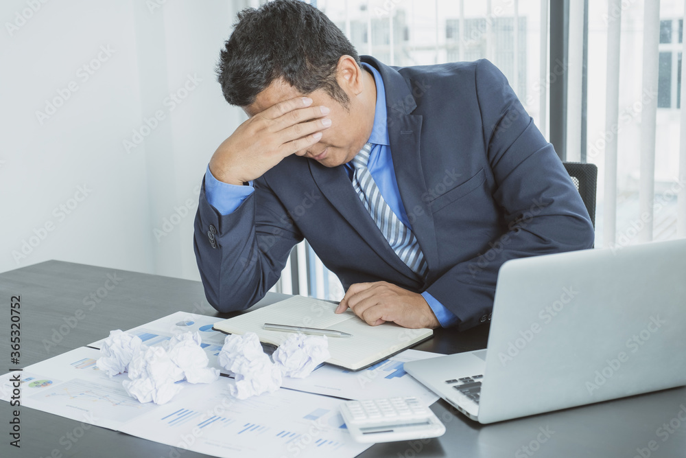 Businessman acted with tired stress anxiety from the frustrated business crisis, paperwork paper cube mess chaos on the table Businessman acted with tired stress anxiety from the frustrated business crisis, paperwork paper cube mess chaos on the table