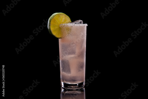 Paloma cocktail in a highball glass, black background