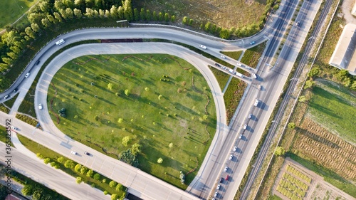 Aerial view of two lane bridge driveway. There is an inner ring road at the bottom. Vehicles and commercial vehicles can also be seen. 